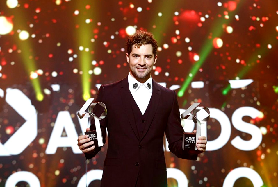 Fotografia de um cantor com o troféu